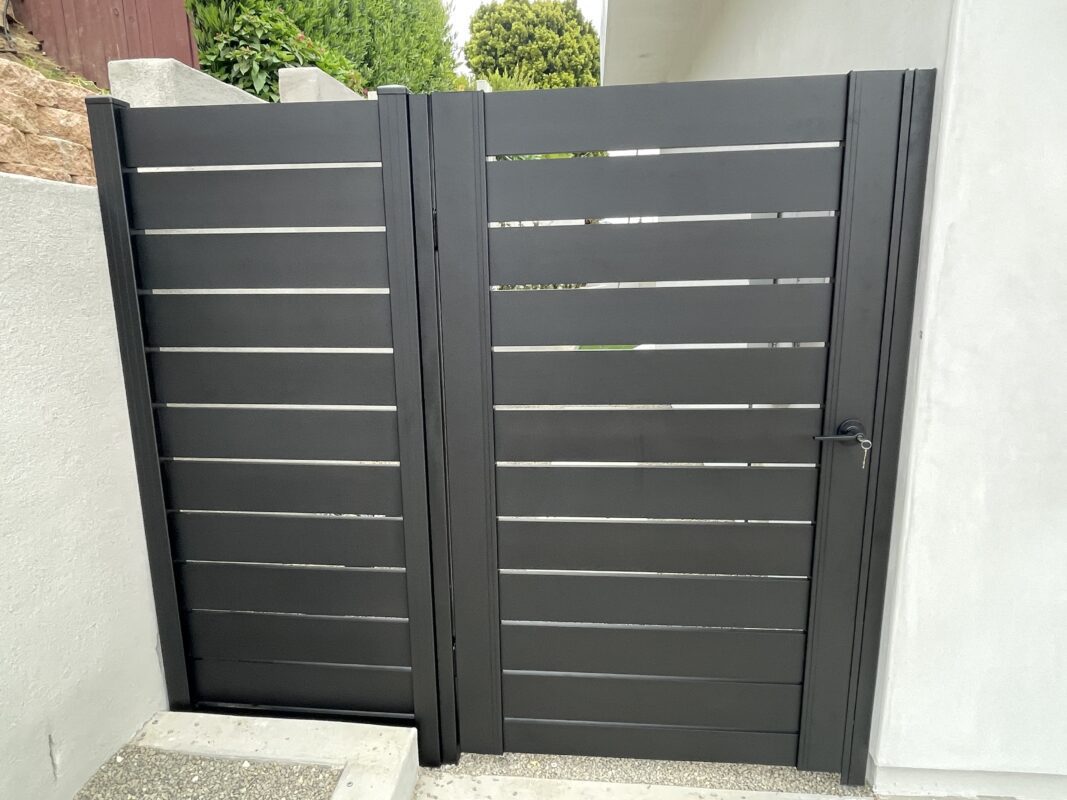 Black Aluminum pedestrian gate installed between homes