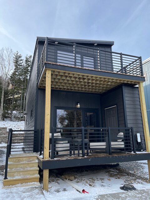 Newly installed black aluminum fencing around a stylish house with outdoor seating.
