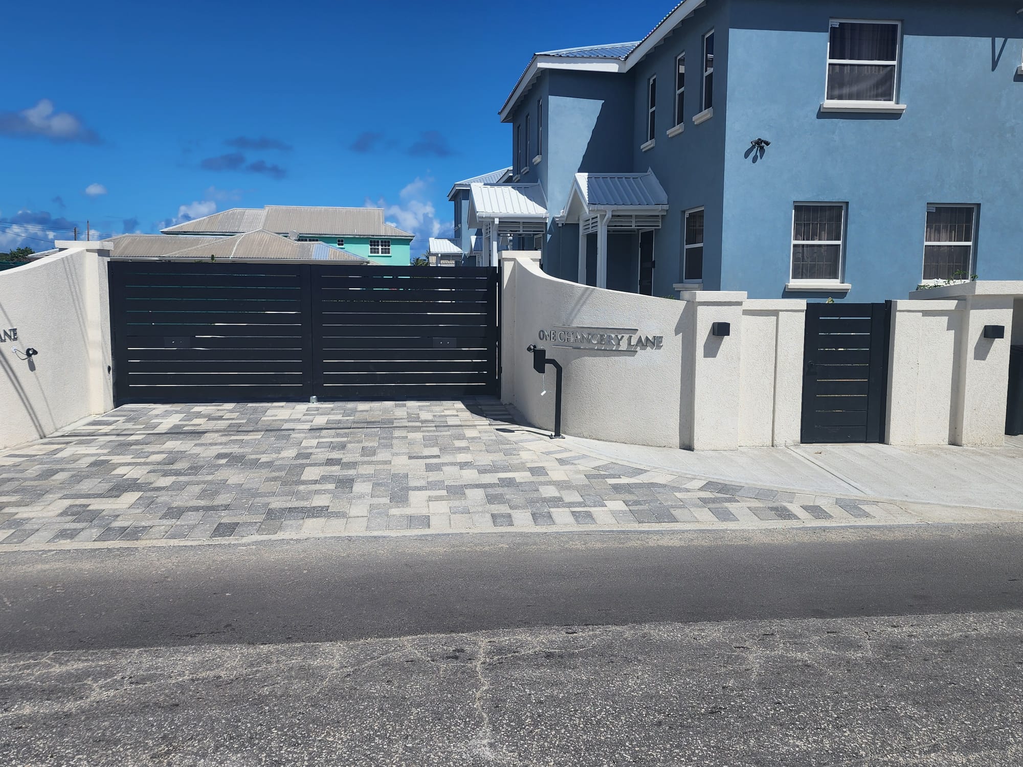 Modern black double swing gate installed at a stylish property in St. James, Barbados.