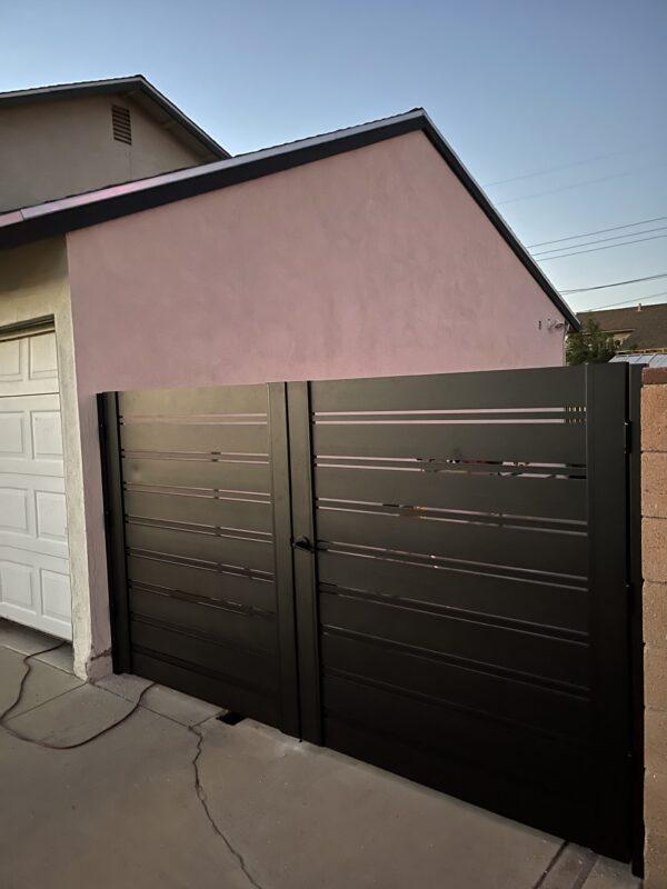 Modern black aluminum double swing gates installed in a residential setting.