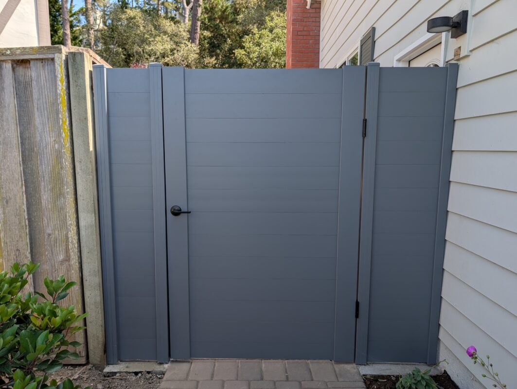 Modern light gray aluminum fence gate with handle, blending functionality and aesthetics.