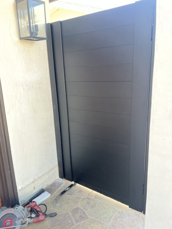 Modern matte black aluminum gate installed, enhancing privacy and safety.