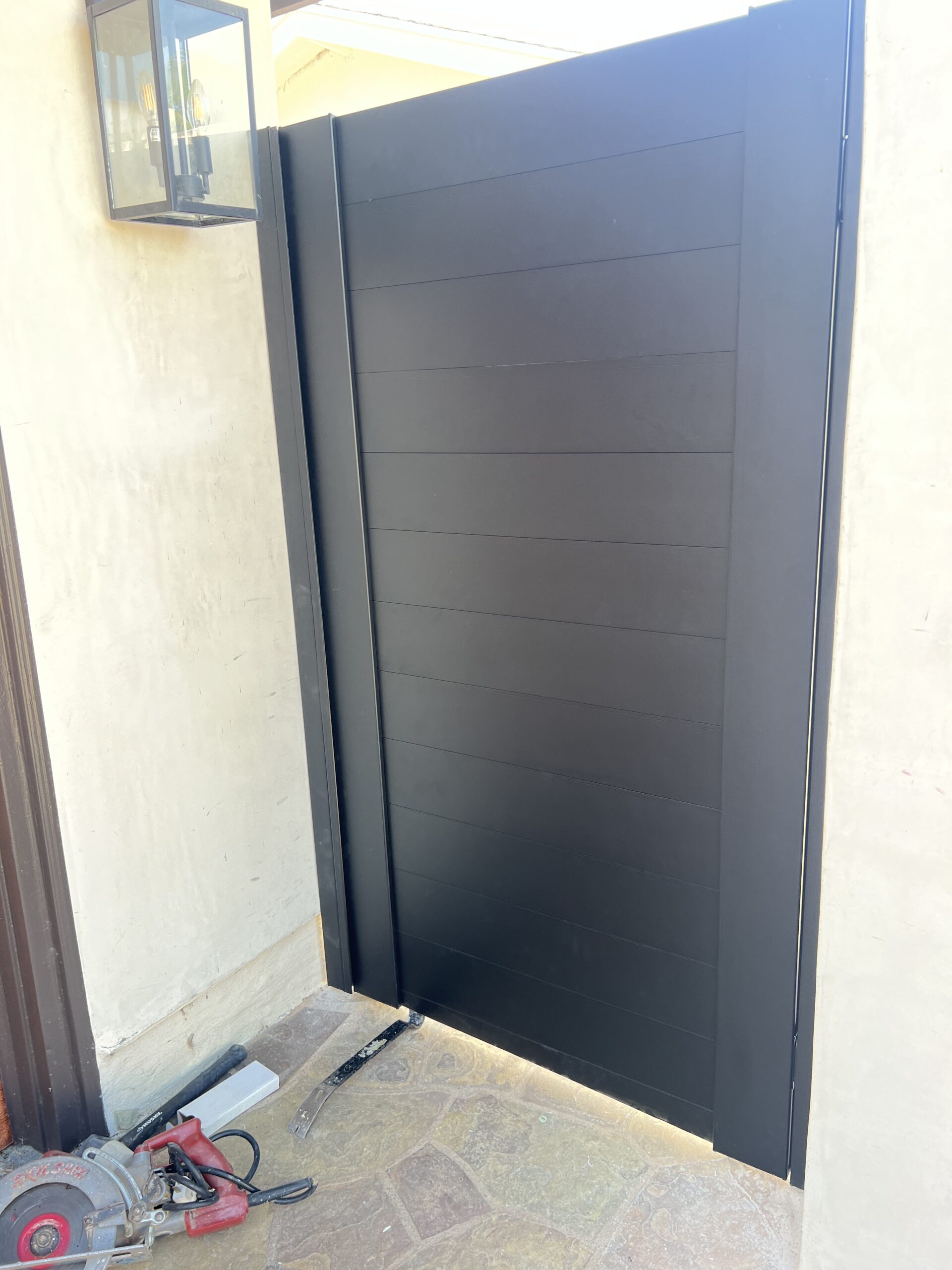 Modern matte black aluminum gate installed, enhancing privacy and safety.