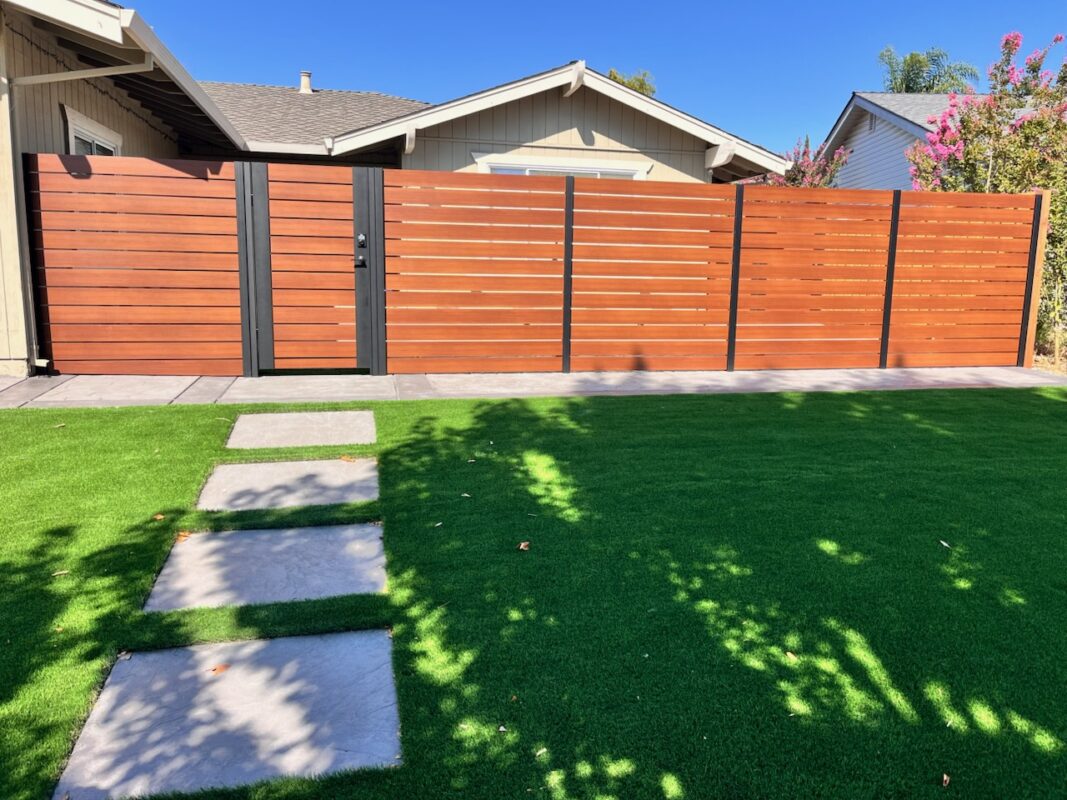 Modern aluminum fence with wood finish and gate in a San Jose backyard, adding privacy.
