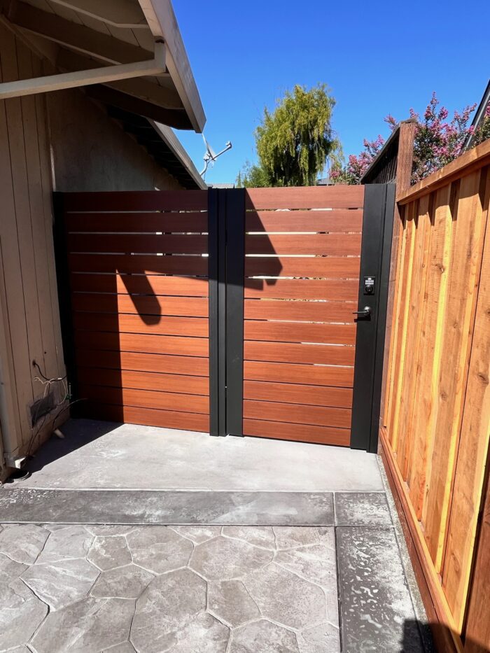 Wood-look horizontal aluminum pedestrian gate and fixed panel with black framing in San Jose, California