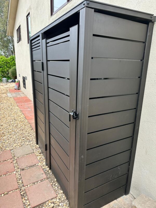 Modern bronze aluminum gates installed beside a residential building.