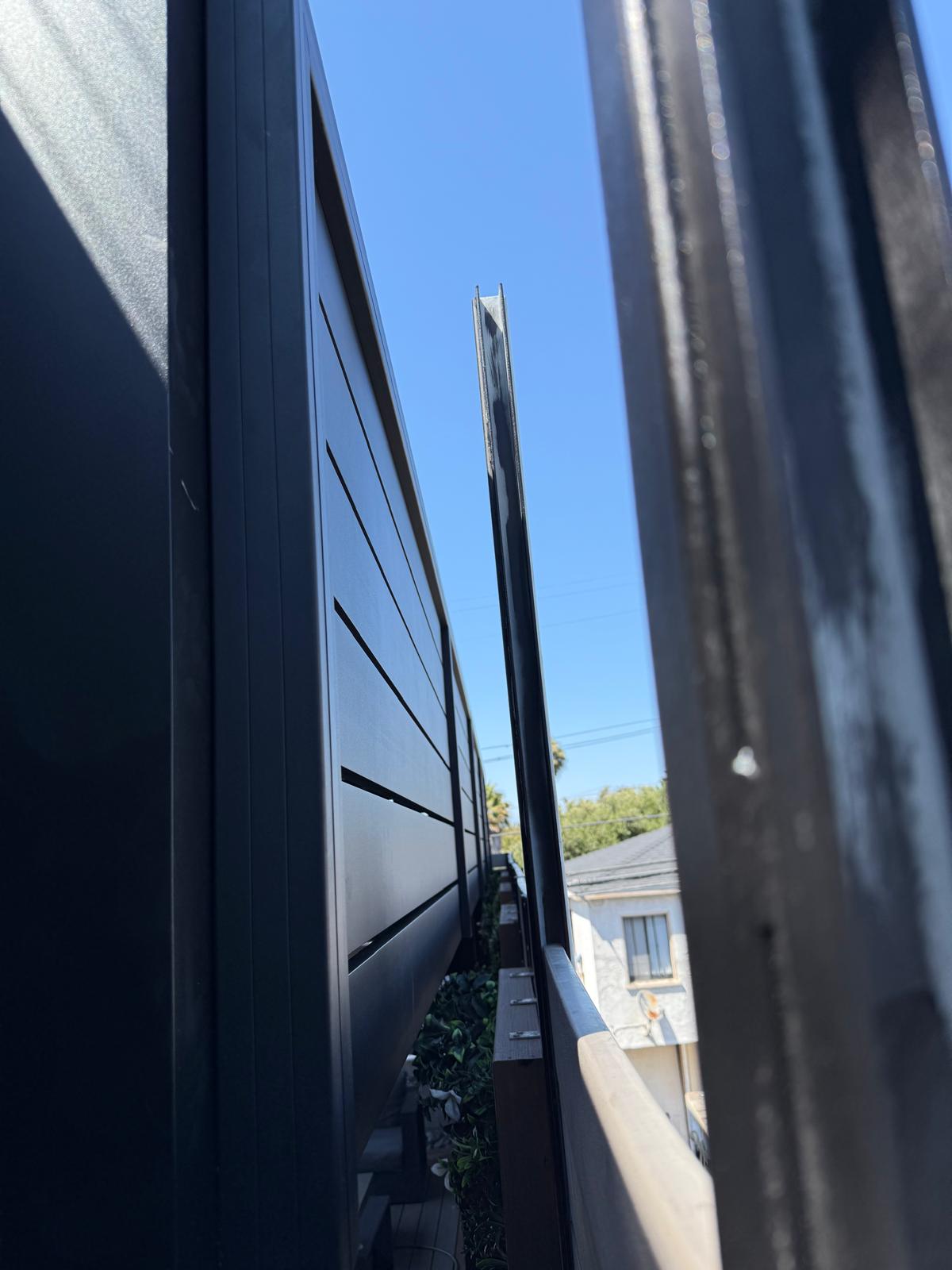 Close-up of matte-black aluminum privacy screen installation in sunny Redondo Beach.