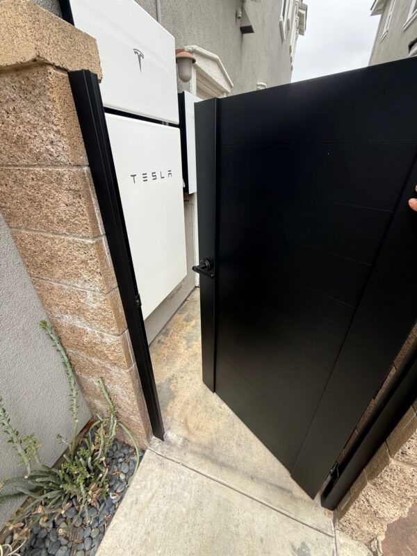 Matte black aluminum gate opening in Tustin, CA, showcasing modern privacy design.
