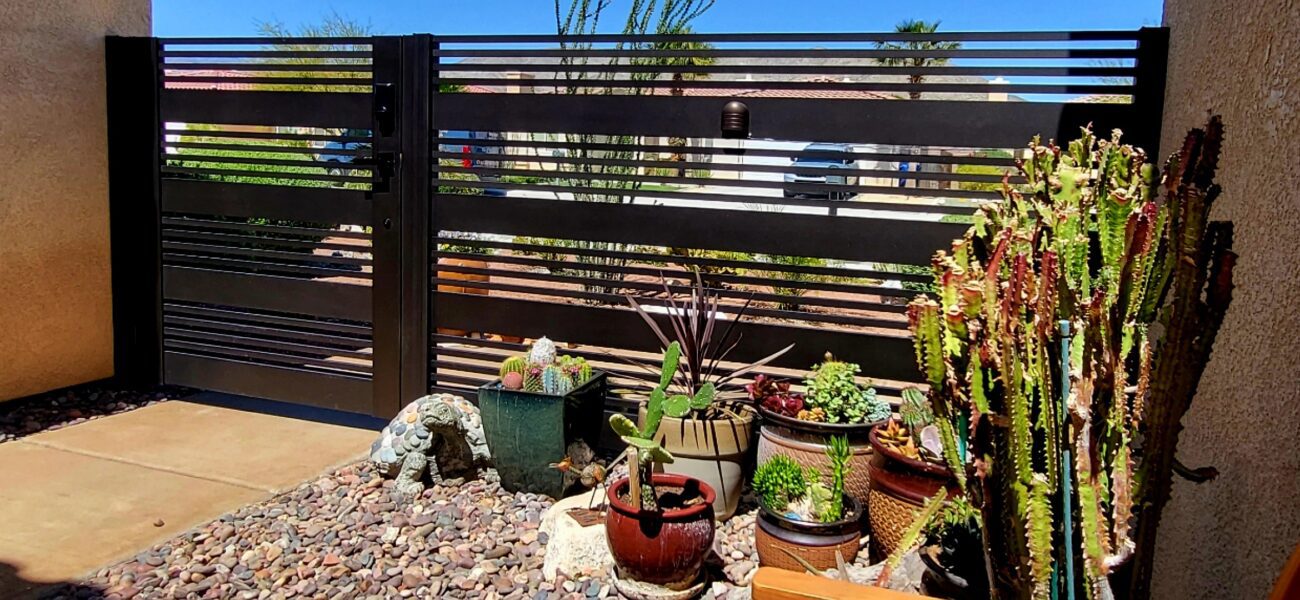 Modern aluminum fence gate with semi-privacy slats beside a garden in Van Nuys, CA.