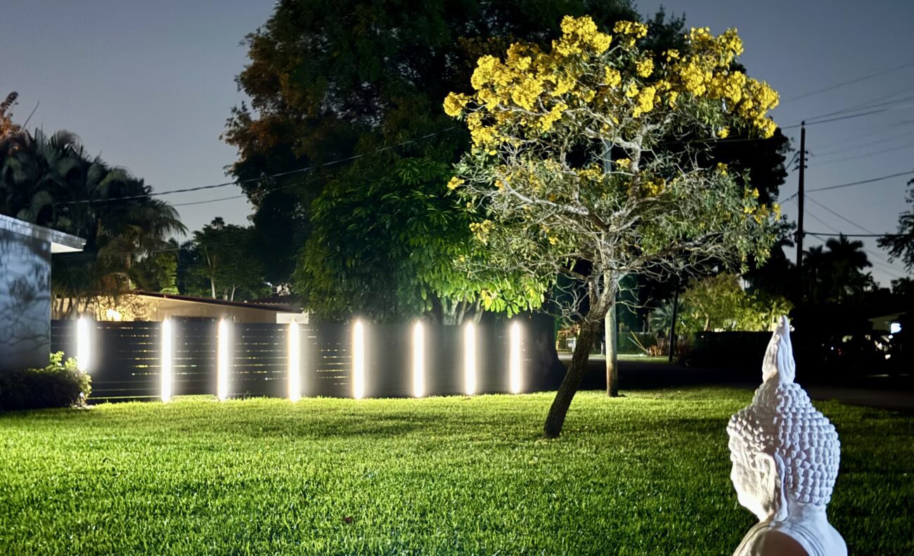 Aluminum fence installation with built-in lights highlighting a landscaped yard.