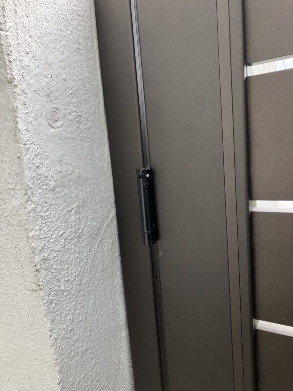 Close-up of a bronze aluminum pedestrian gate with sleek horizontal slats.