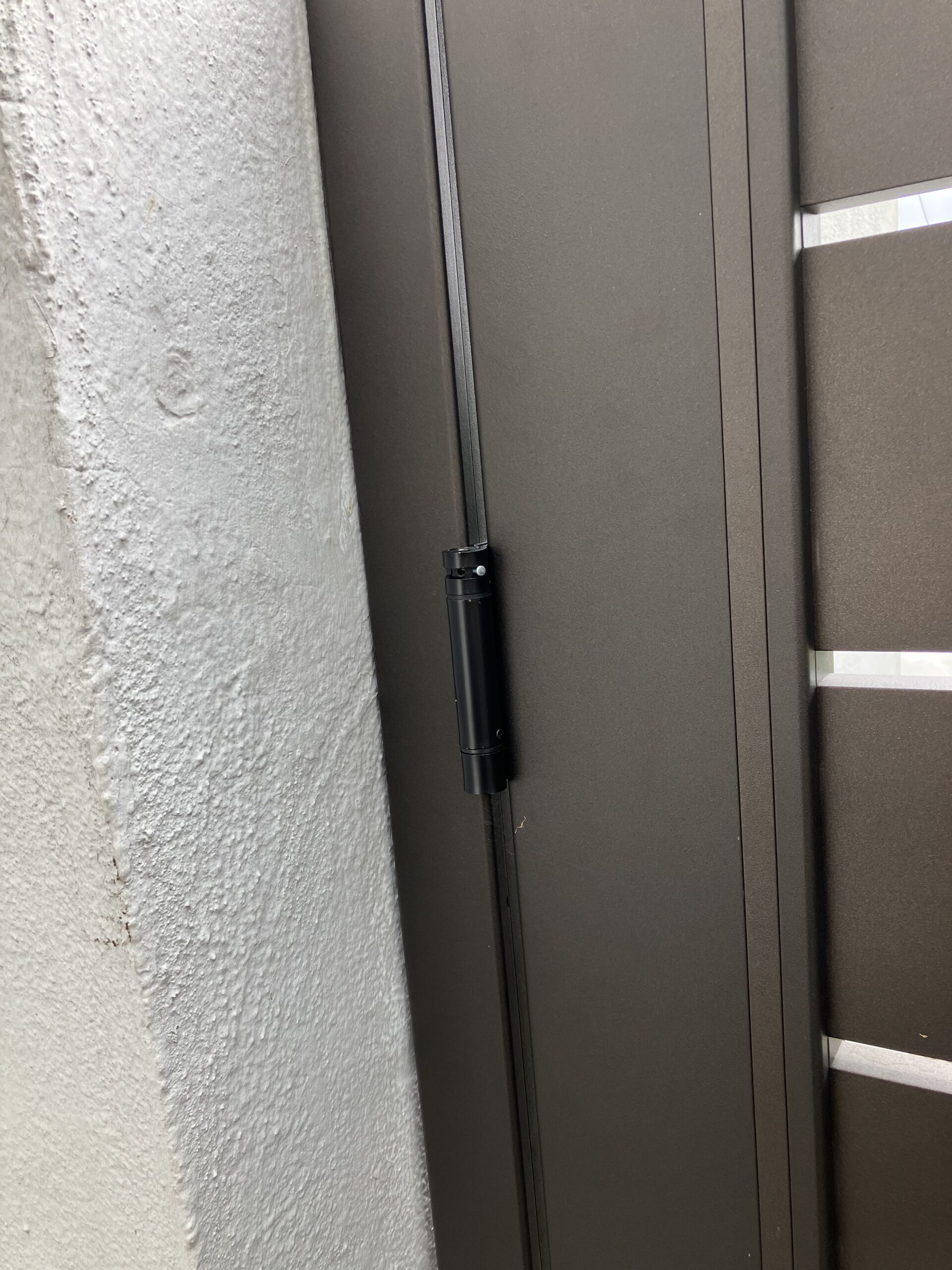 Close-up of a bronze aluminum pedestrian gate with sleek horizontal slats.