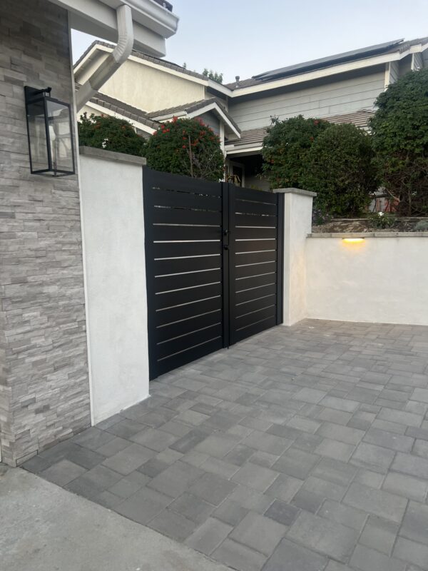 Stylish black aluminum gates with horizontal slats in a driveway setting, Granada Hills, CA.