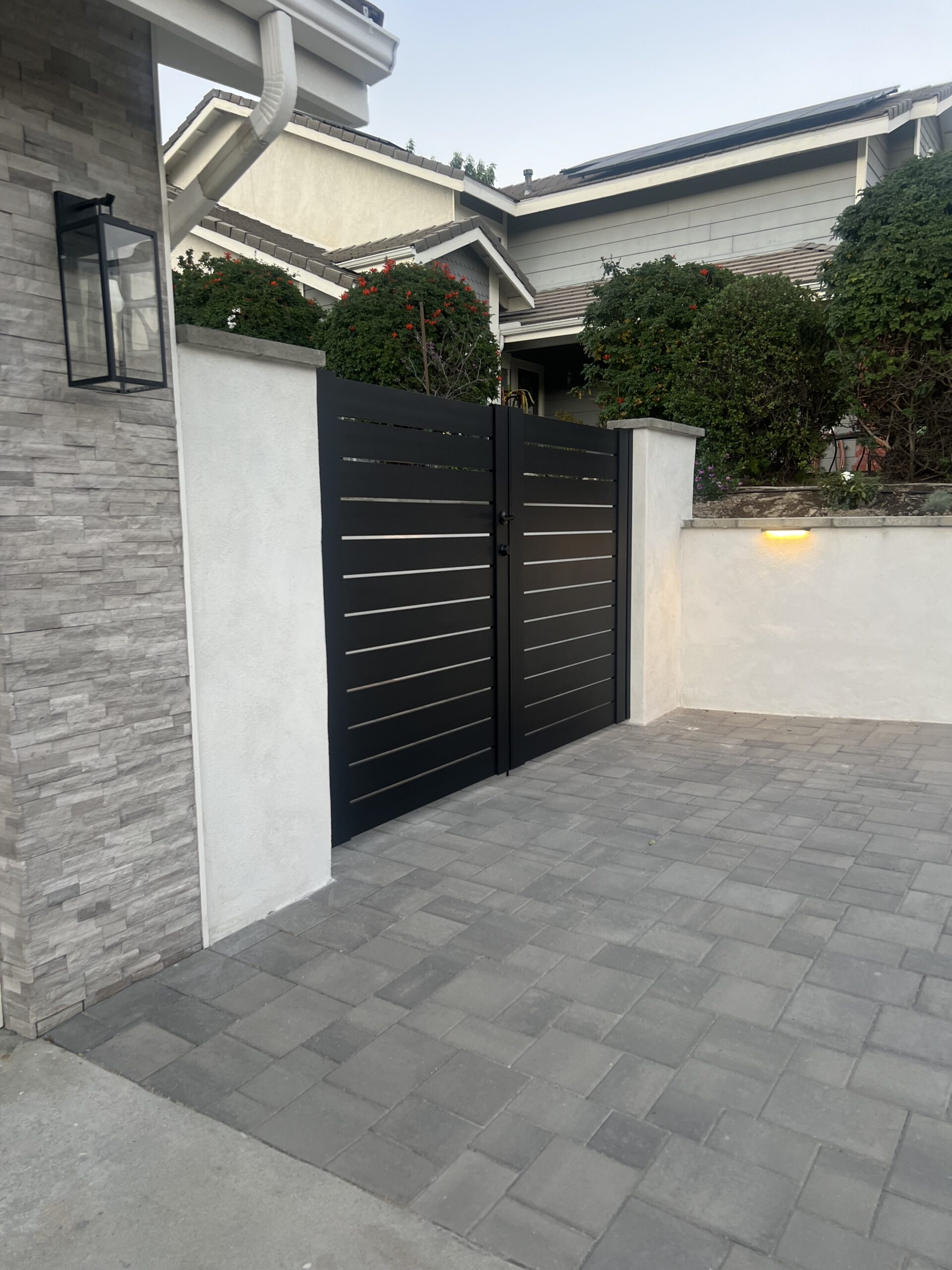 Stylish black aluminum gates with horizontal slats in a driveway setting, Granada Hills, CA.