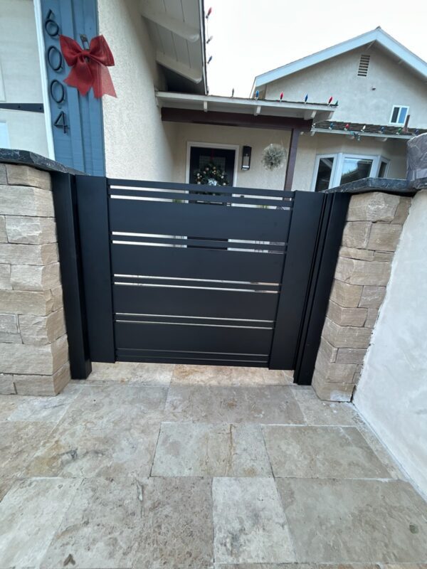 Modern black aluminum gate with horizontal slats at entrance in Ventura, CA.