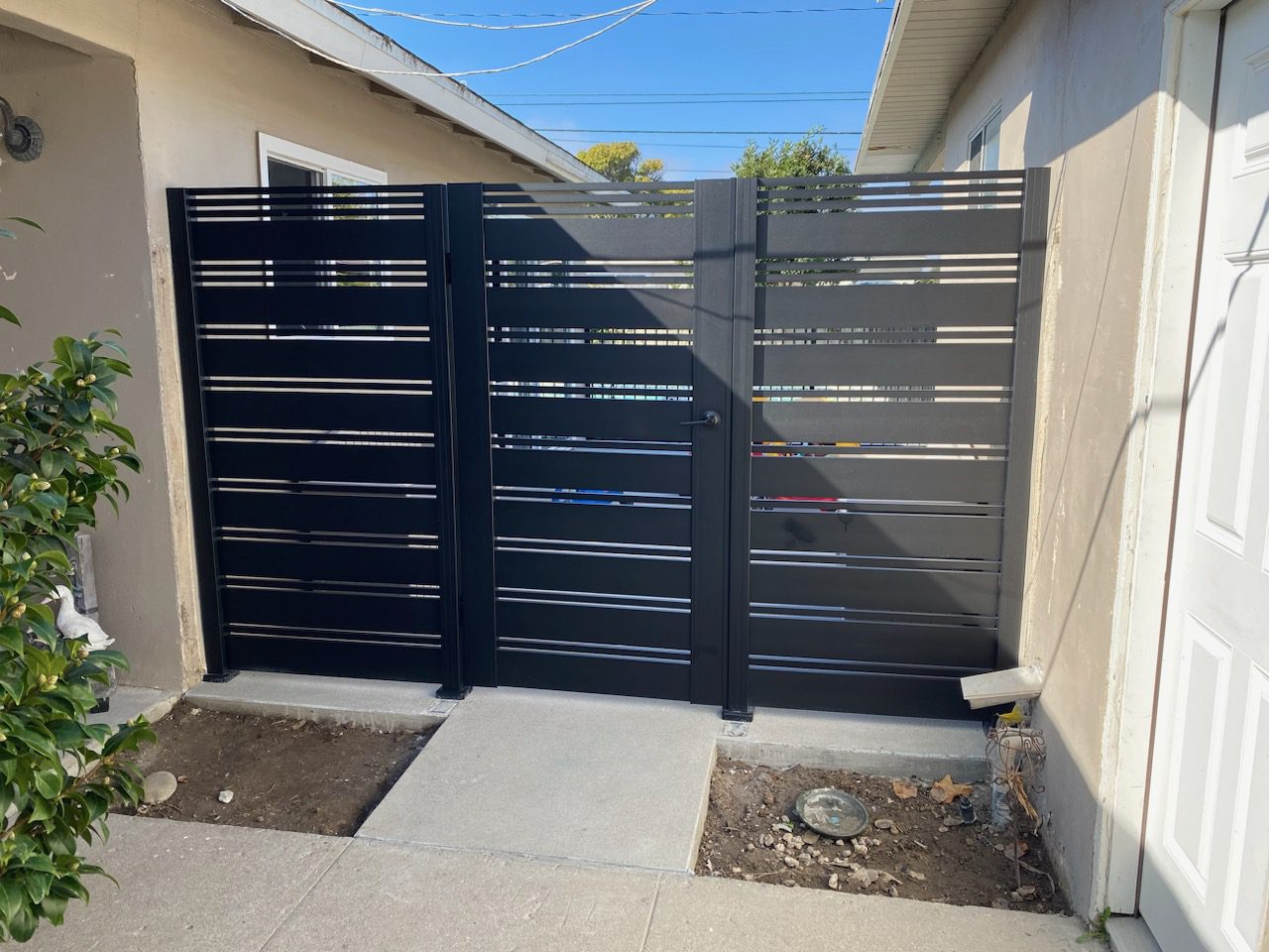 Modern black aluminum gate with side panels installed in Point Mugu, CA, enhancing privacy.
