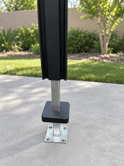Surface-mounted aluminum fence post base anchored to concrete