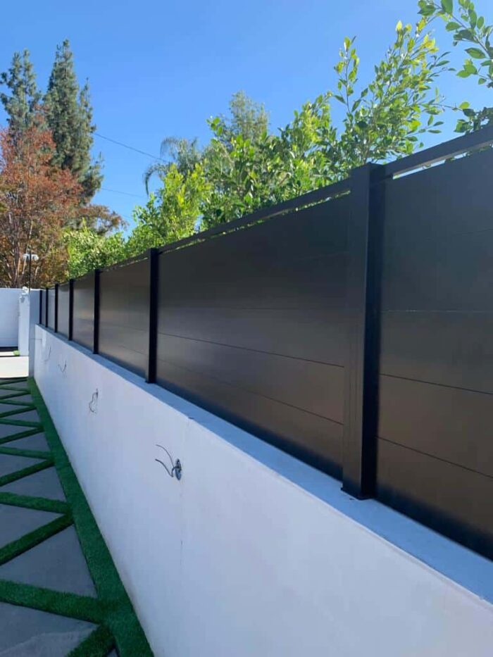 Black full-privacy aluminum wall topper with an open accent at the top in Boca Grande, Florida