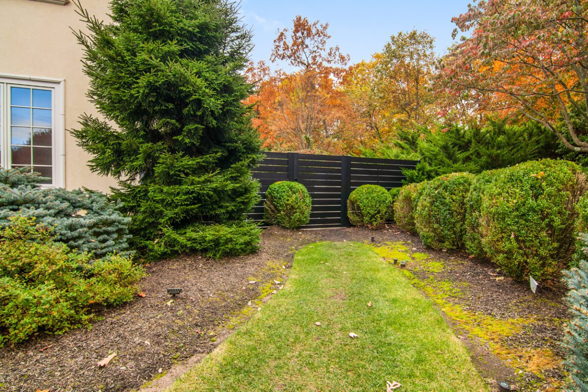 Modern black aluminum fence amidst landscaped greenery in Cedar Grove, NJ.