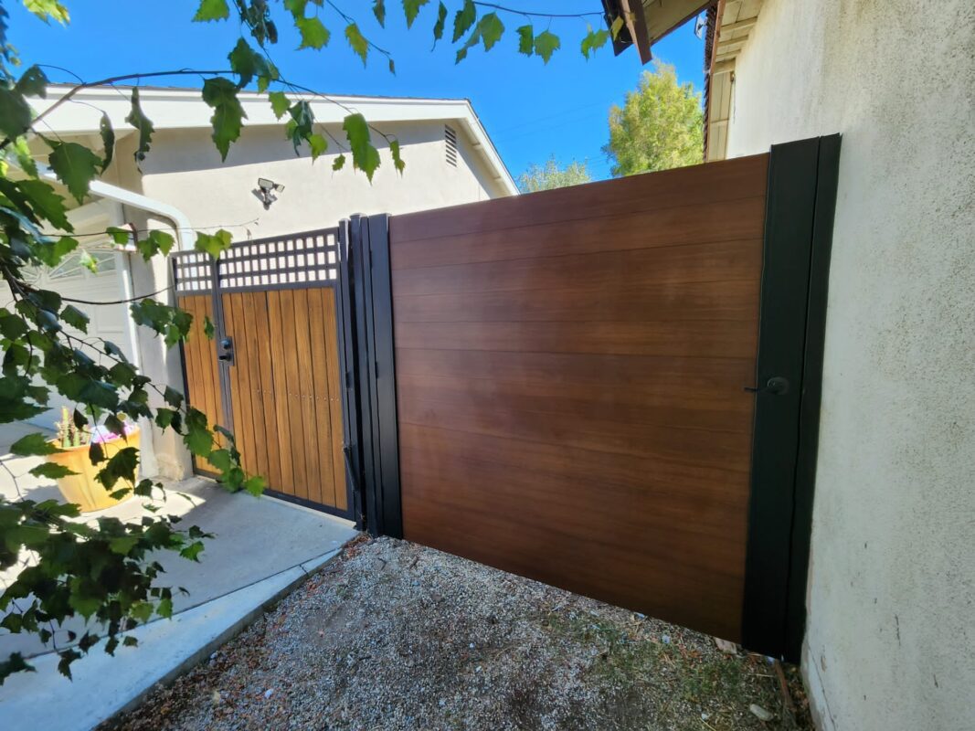 A modern wood-look gate flanked by a smaller gate, enhancing privacy and aesthetics.