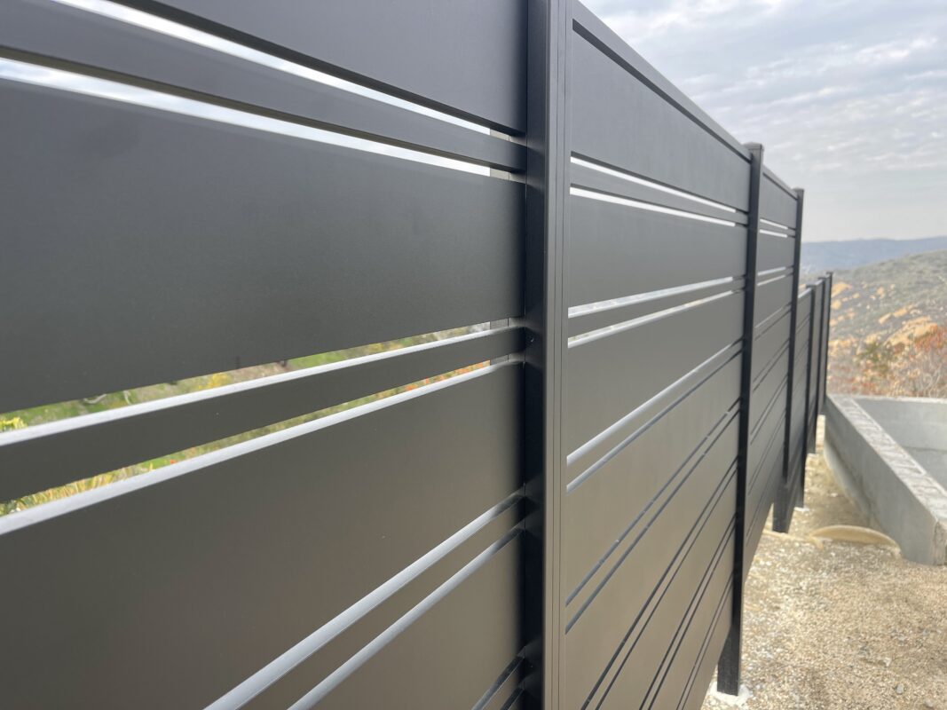 Close-up of sleek black aluminum fence panels in Laguna Beach installation.