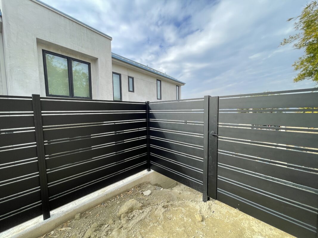 A newly installed black aluminum fence surrounding a modern home in Laguna Beach.