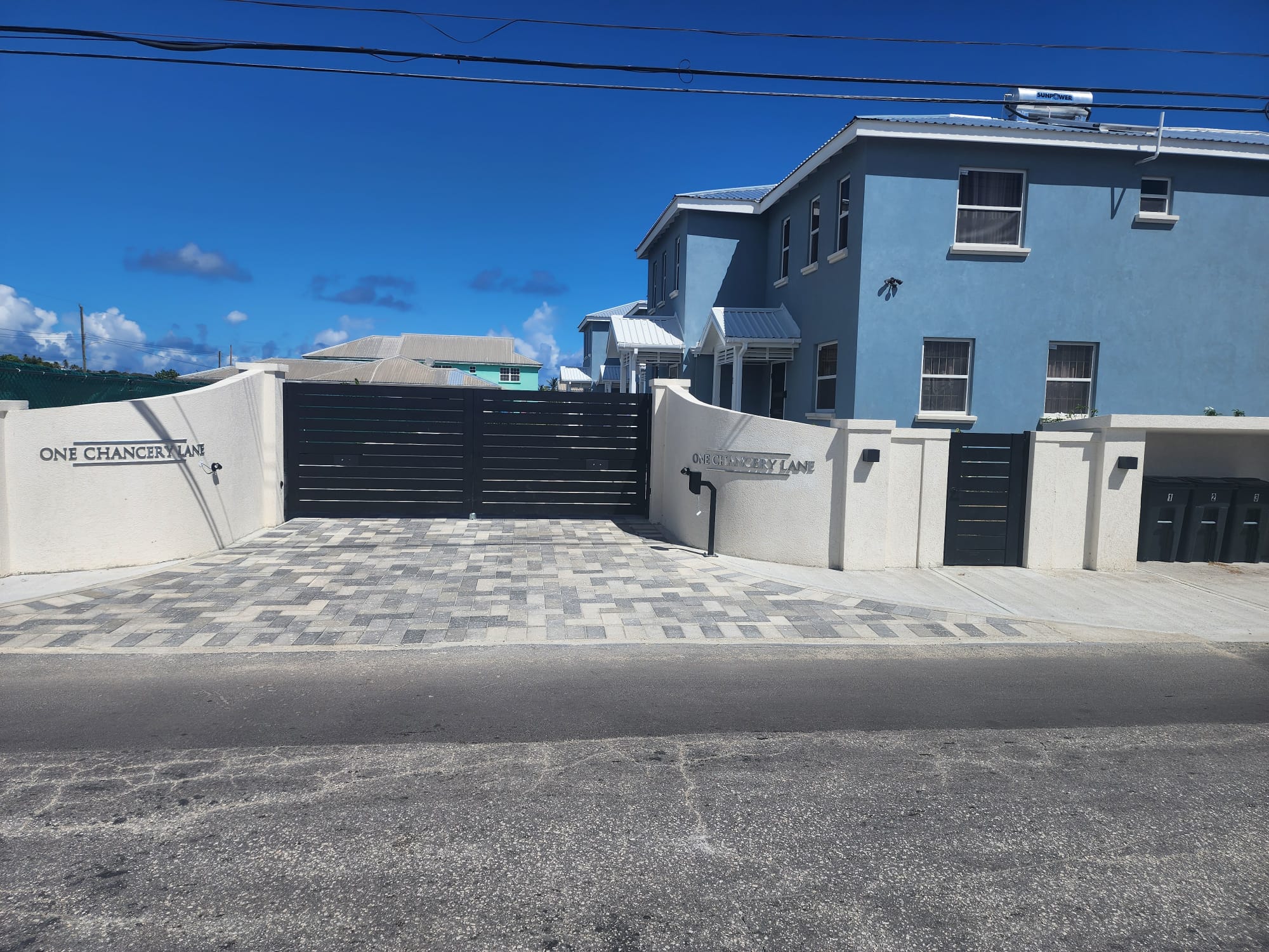 Elegant black double swing gate at a modern home entrance in St. James, Barbados.