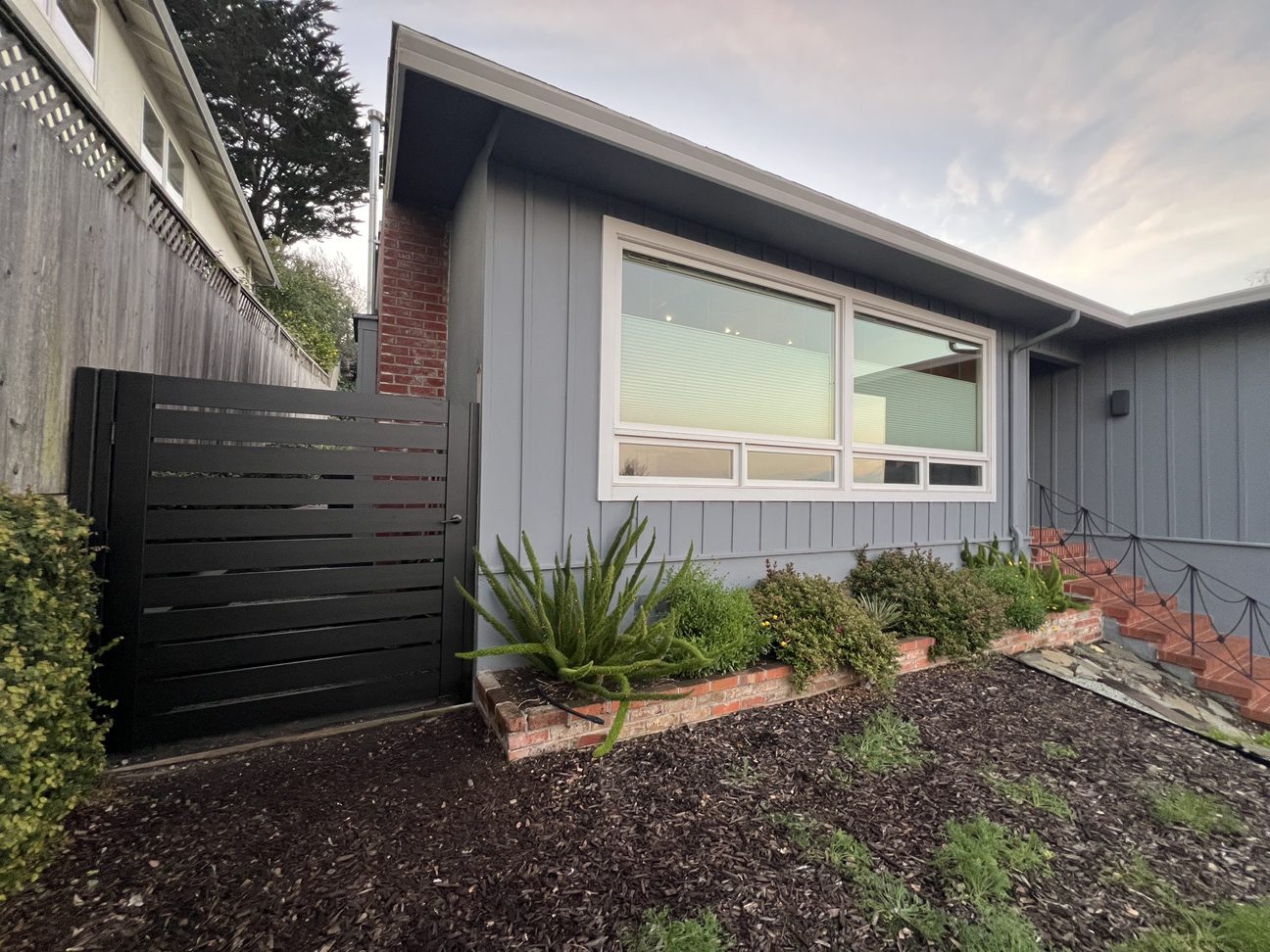 A sleek black LA style gate enhances a home's entryway, adding security and style.
