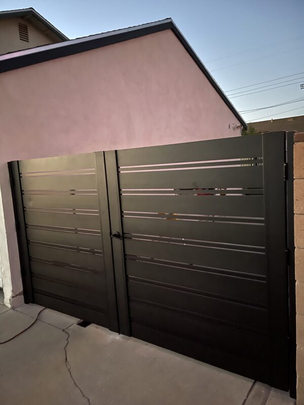 Black aluminum double swing gates installed, enhancing property security and aesthetics.