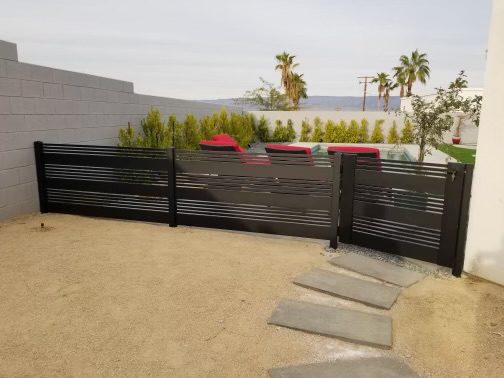 Matte black aluminum fence with horizontal slats surrounding a yard in Cathedral City, CA.