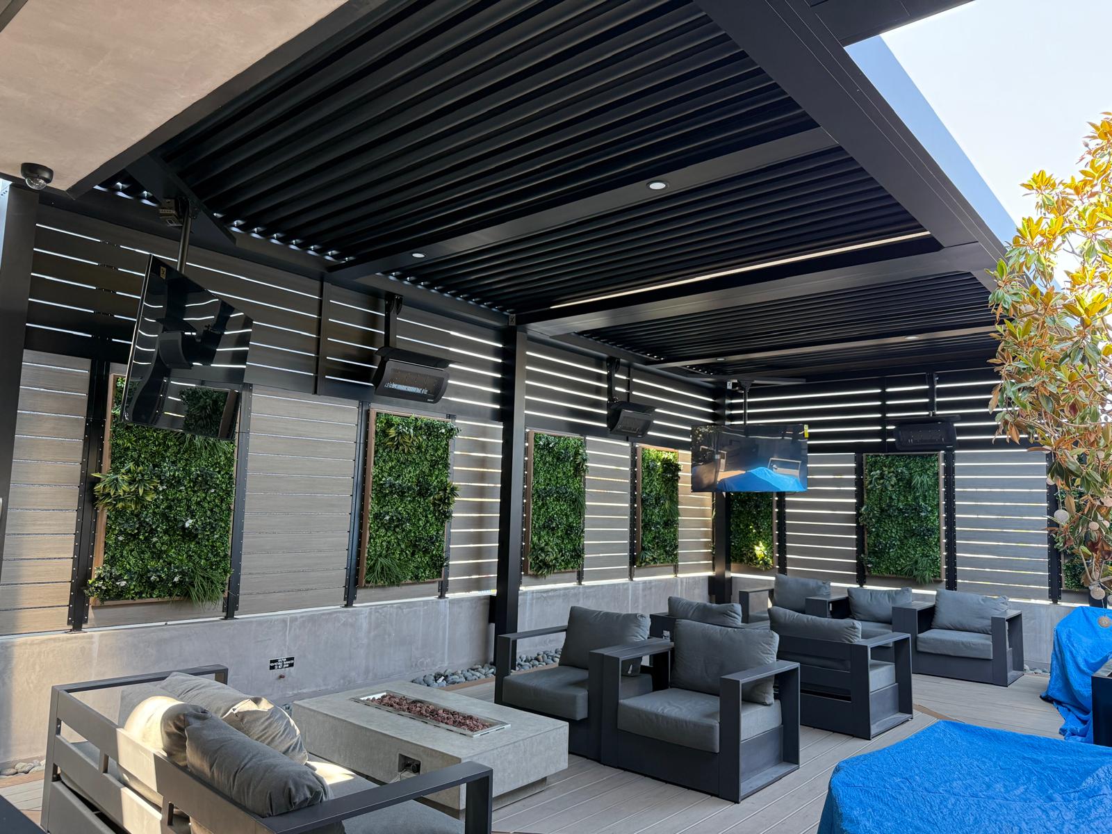 Modern matte-black aluminum privacy screen with slat enclosures in a stylish patio area.