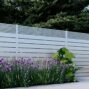 White Dallas Style Alumission aluminum fence kit installed in a landscaped yard