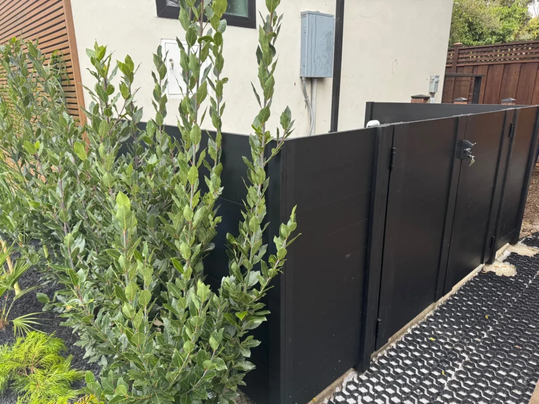 Black full privacy enclosure panels enclosing outdoor mechanical equipment with vertical black posts.